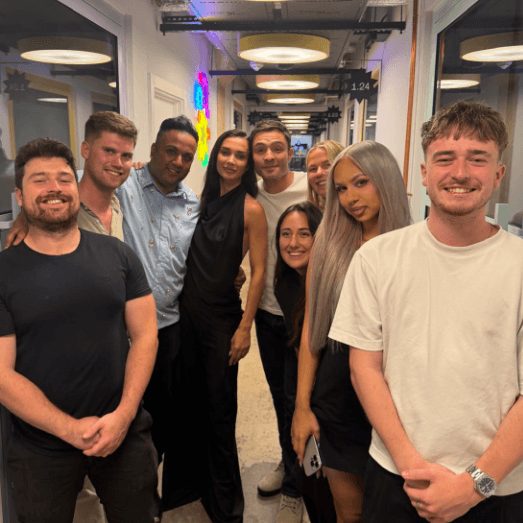 A group of the team gathered in an office corridor